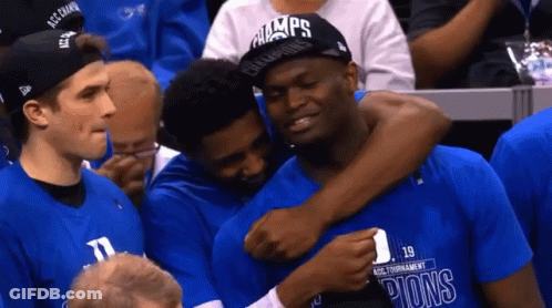 A Man Wearing A Hat That Says Champions On It Is Hugging Another Man GIF