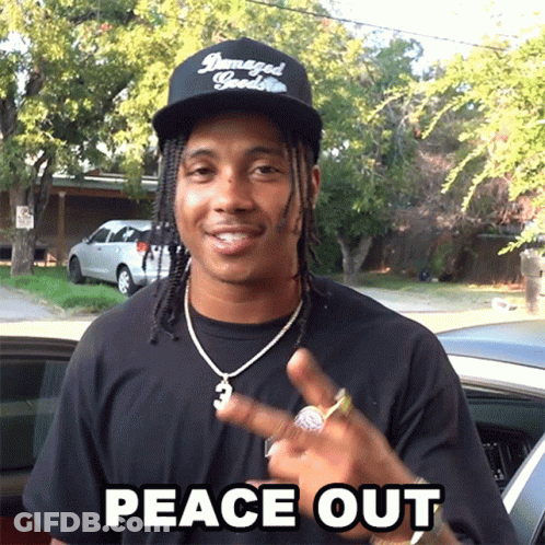 A Man Wearing A Hat That Says Damaged Goods Is Giving The Peace Sign GIF