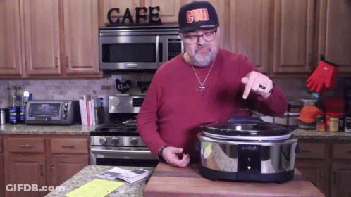 A Man Wearing A Hat That Says Grill Is Standing In Front Of A Stove In A Kitchen GIF