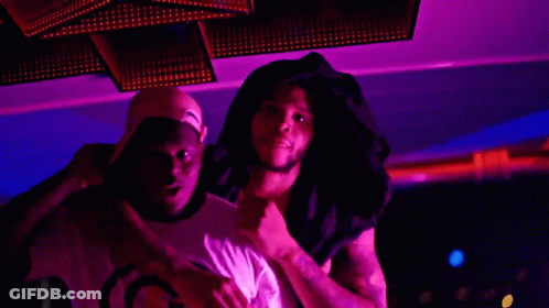 A Man Wearing A Hat That Says Gucci On It Stands Next To Another Man GIF