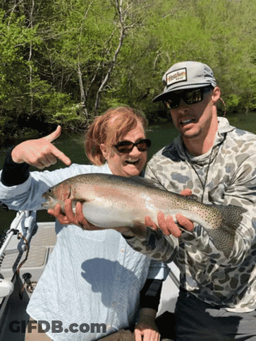 A Man Wearing A Hat That Says Hooker On It Holds A Large Fish GIF