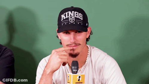 A Man Wearing A Hat That Says Kings Is Sitting In Front Of A Microphone GIF