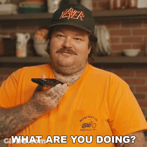 A Man Wearing A Hat That Says Slayer Is Holding A Phone And Asking What Are You Doing GIF