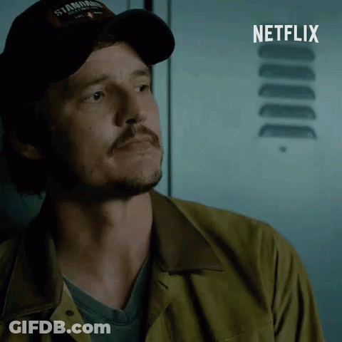 A Man Wearing A Hat That Says ' Stanford ' On It Stands In Front Of A Netflix Logo GIF