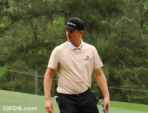 A Man Wearing A Hat That Says Stanley Is Walking On A Golf Course GIF
