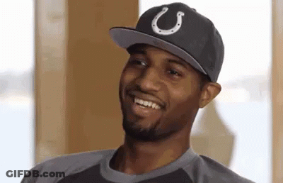 A Man Wearing A Hat With A Horseshoe On It Is Smiling And Looking At The Camera . GIF