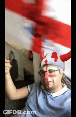 A Man Wearing A Hat With Horns And A Red Cross On It GIF
