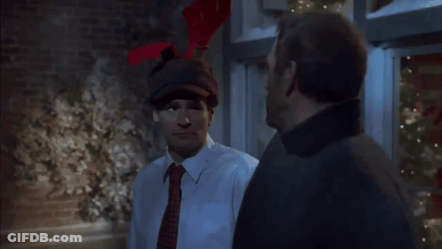A Man Wearing A Hat With Reindeer Antlers Is Talking To Another Man GIF