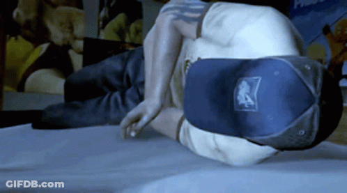 A Man Wearing A Hat With The Letter A On It Is Laying On A Bed GIF