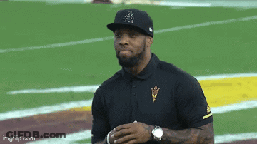 A Man Wearing A Hat With The Letter A On It Stands On A Football Field .. GIF