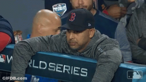 A Man Wearing A Hat With The Letter B On It Sits In The Dugout GIF
