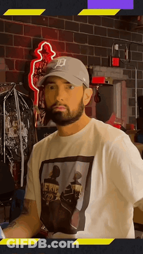 A Man Wearing A Hat With The Letter D On It Is Standing In Front Of A Brick Wall .. GIF