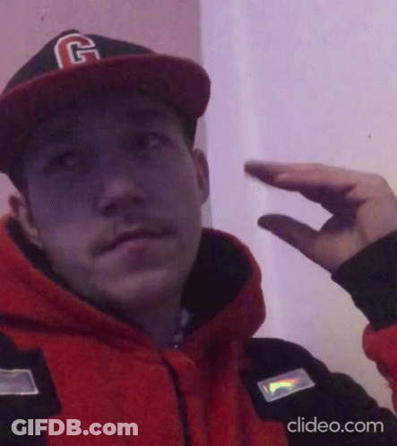 A Man Wearing A Hat With The Letter G On It Is Making A Hand Gesture GIF