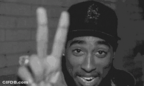 A Man Wearing A Hat With The Letter R On It Giving A Peace Sign GIF
