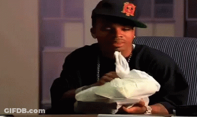 A Man Wearing A Hat With The Letter R On It Is Sitting At A Table Holding A Piece Of Paper . GIF