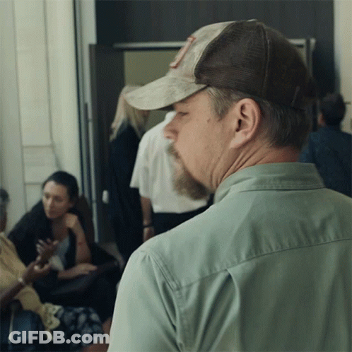 A Man Wearing A Hat With The Letter R On It Looks To His Left GIF