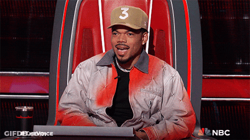 A Man Wearing A Hat With The Number 3 On It Is Sitting In A Chair GIF