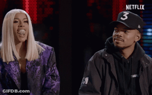 A Man Wearing A Hat With The Number 3 On It Stands Next To A Woman In A Purple Jacket GIF