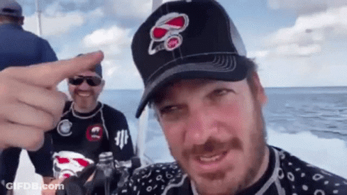 A Man Wearing A Hat With The Number 80 On It Is Pointing GIF