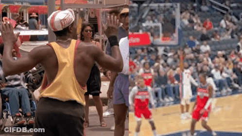 A Man Wearing A Hat With The Word Ferrari On It Stands In Front Of A Basketball Court GIF