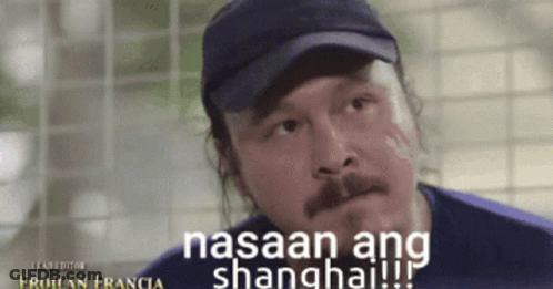 A Man Wearing A Hat With The Words Nasaan Ang Shanghai On It GIF