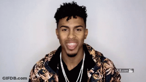 A Man Wearing A Hawaiian Jacket Is Smiling In Front Of A Mlb.com Logo GIF