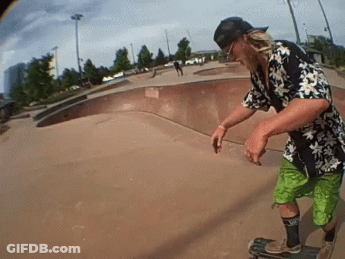 A Man Wearing A Hawaiian Shirt And Green Shorts Rides A Skateboard GIF