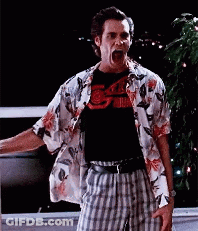A Man Wearing A Hawaiian Shirt And Plaid Pants Is Standing In Front Of A Window With His Mouth Open . GIF