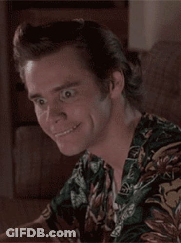 A Man Wearing A Hawaiian Shirt Is Smiling And Looking At The Camera GIF