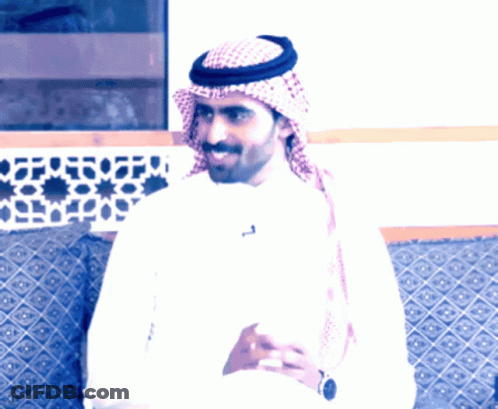A Man Wearing A Head Scarf And A White Shirt Has A Letter T On His Shirt GIF