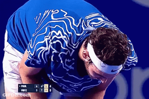 A Man Wearing A Headband And A Blue Shirt Looks Down At A Scoreboard That Says Paul Fritz GIF