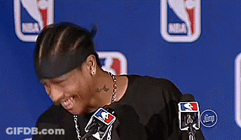 A Man Wearing A Headband And A Necklace Is Standing In Front Of A Microphone . GIF