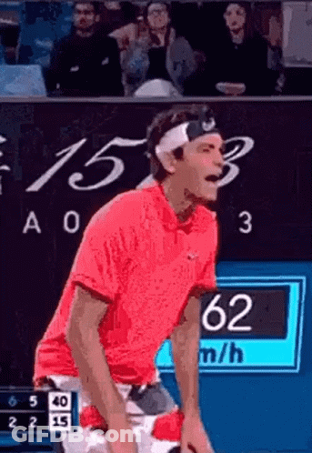 A Man Wearing A Headband And A Red Shirt Is Playing Tennis . GIF
