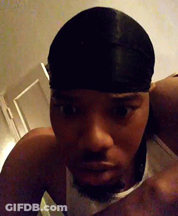 A Man Wearing A Headband And A Tank Top Looks At The Camera GIF