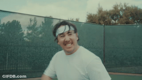 A Man Wearing A Headband And A White Shirt Is Playing Tennis GIF