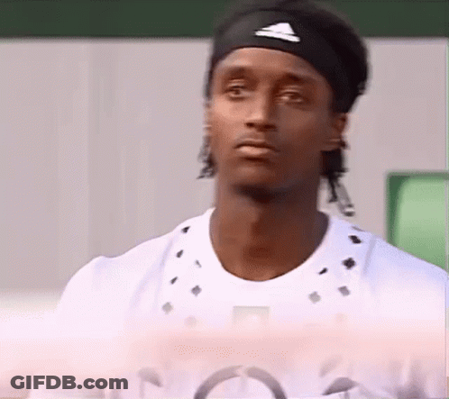 A Man Wearing A Headband And A White Shirt Looks At The Camera . GIF