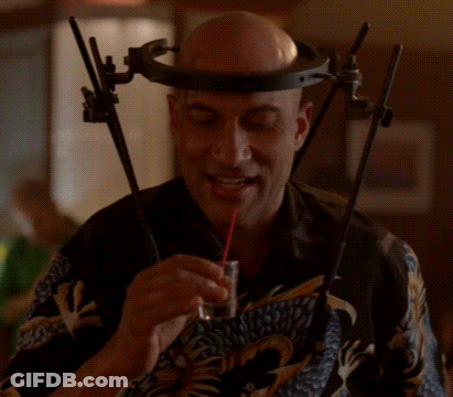 A Man Wearing A Headband And Glasses Is Eating Something GIF