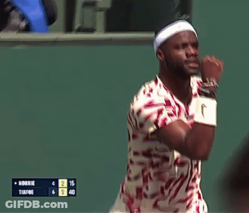 A Man Wearing A Headband And Nike Wristbands Holds His Fist Up In The Air GIF