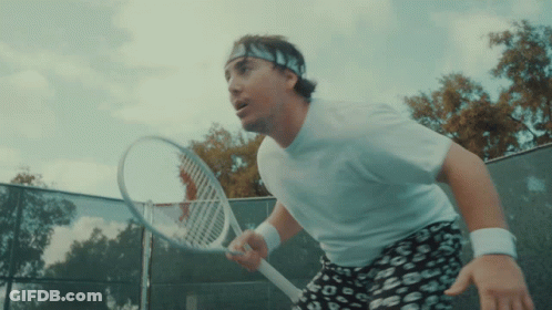 A Man Wearing A Headband Holds A Tennis Racquet On A Tennis Court GIF