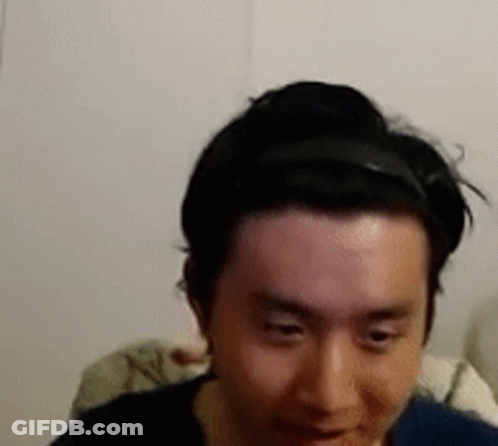 A Man Wearing A Headband Is Looking At The Camera . GIF