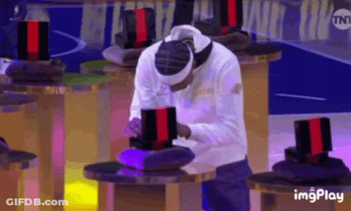 A Man Wearing A Headband Is Sitting At A Table In Front Of A Tnt Sign GIF