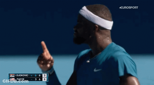 A Man Wearing A Headband Is Smiling On A Tennis Court GIF