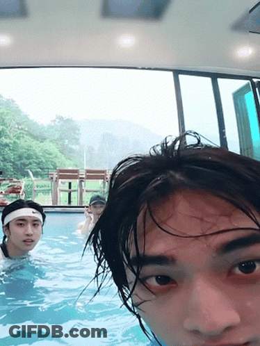 A Man Wearing A Headband Is Swimming In A Pool With Other People GIF