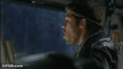 A Man Wearing A Headband Looks Out The Window Of A Car GIF