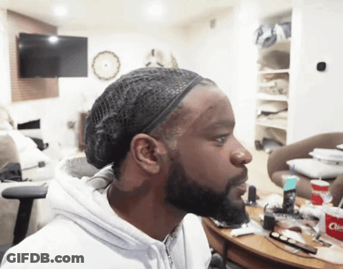 A Man Wearing A Headband Looks To The Side In A Room GIF