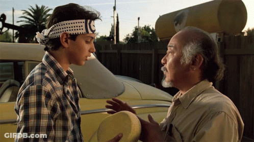A Man Wearing A Headband With A C On It Talks To Another Man GIF