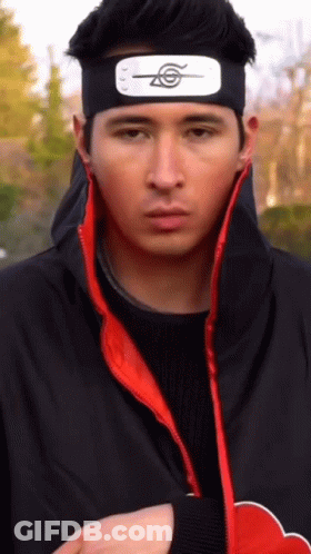 A Man Wearing A Headband With A Symbol On It Is Looking At The Camera GIF
