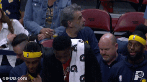 A Man Wearing A Headband With The Letter P On It Sits In The Stands GIF