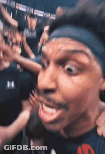 A Man Wearing A Headband With The Letter S On It Is Smiling GIF