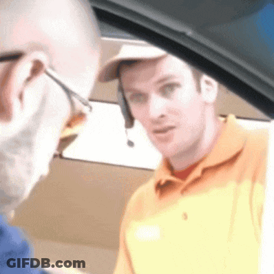 A Man Wearing A Headset Is Talking To Another Man While Sitting In A Car . GIF